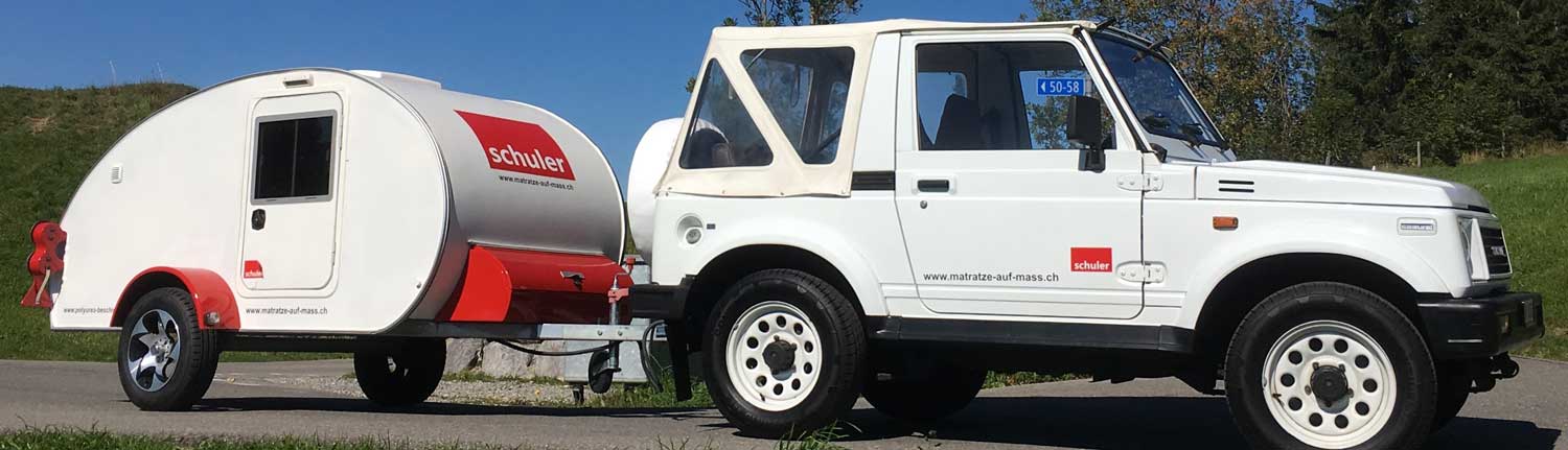 Ein kleiner weißer Truck mit einem angehängten Wohnmobil.